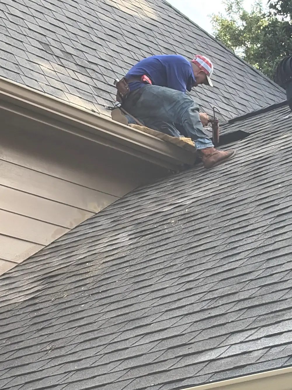 Roofing crew repairing decking at the roof edge of a Katy, TX home