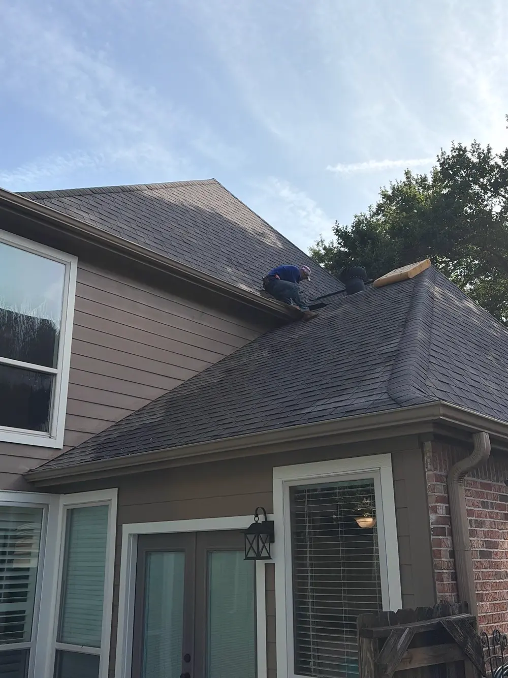 Roofing crew replacing shingles and decking on a home in Katy, TX