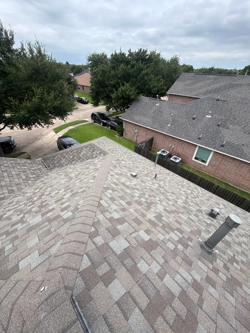 Newly completed architectural shingle roof on a brick home in Pearland, TX viewed from the ridge