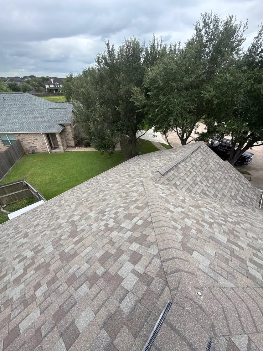 New architectural shingle roof on a brick home in Pearland, TX, seen from the ridge